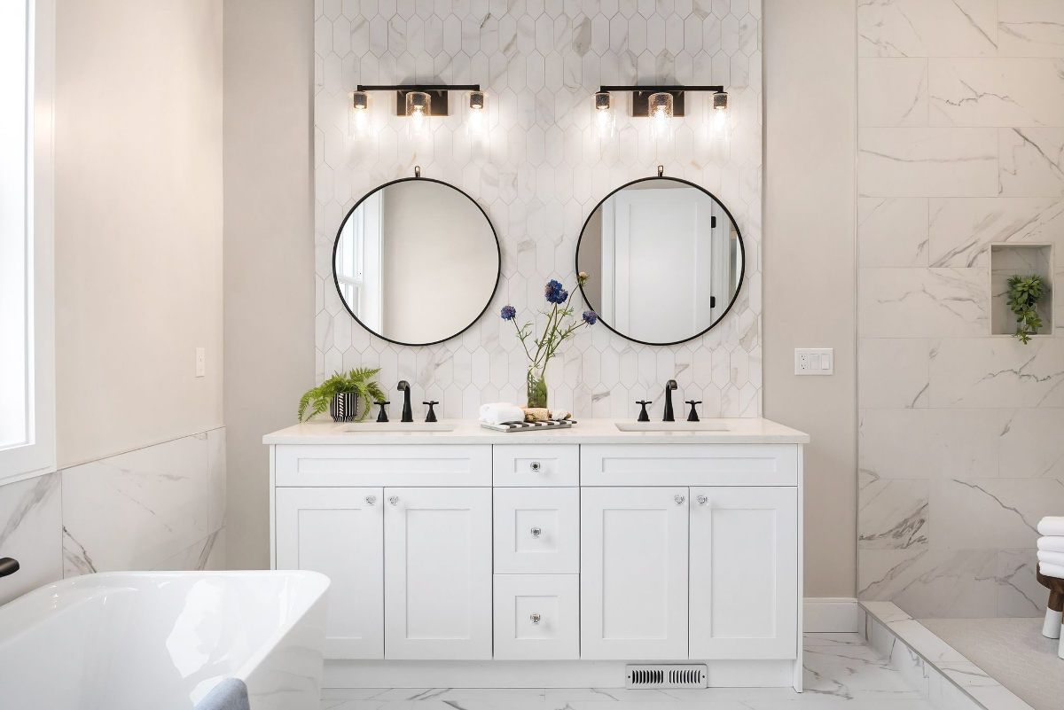 A bathroom with two sinks , two mirrors and a bathtub.