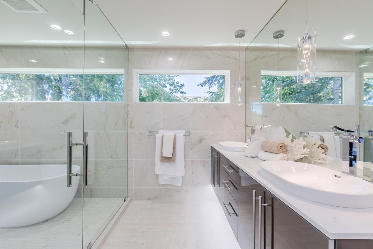 A bathroom with two sinks and a walk in shower