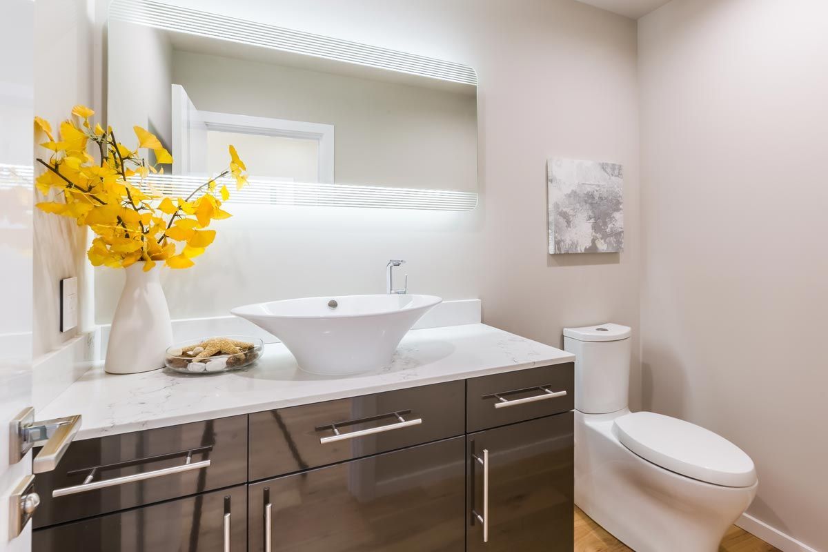 A bathroom with a sink , toilet and mirror.