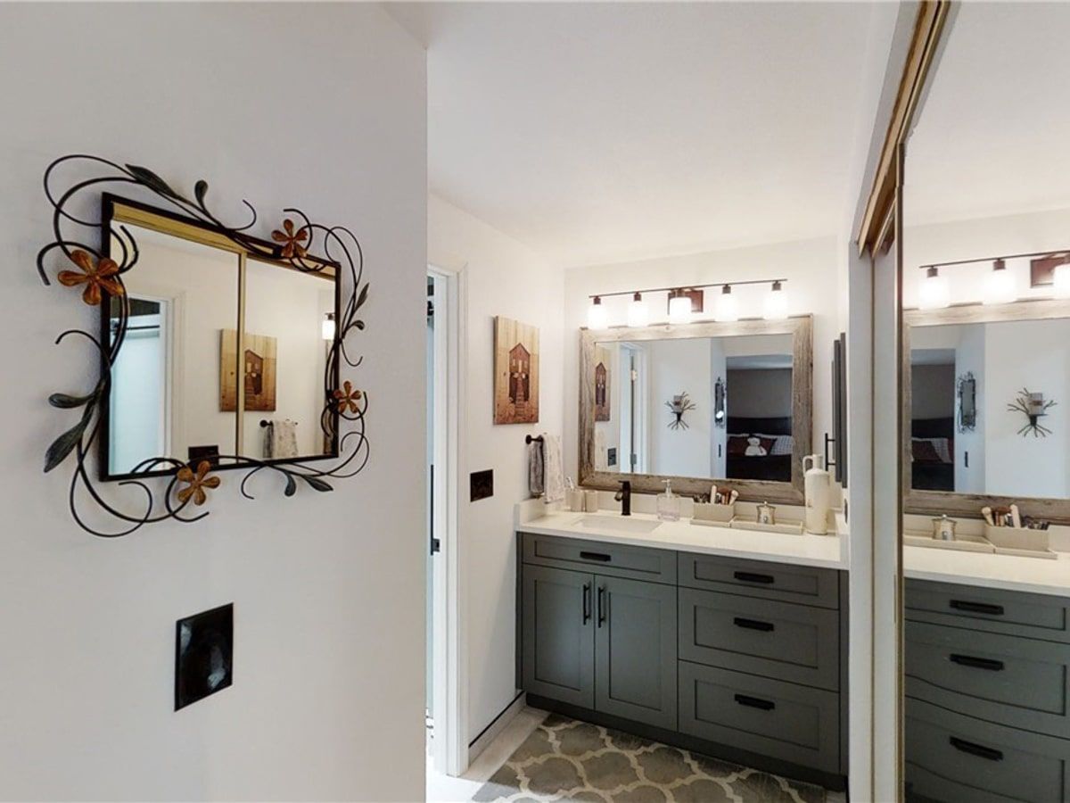 A bathroom with two sinks and a large mirror on the wall.