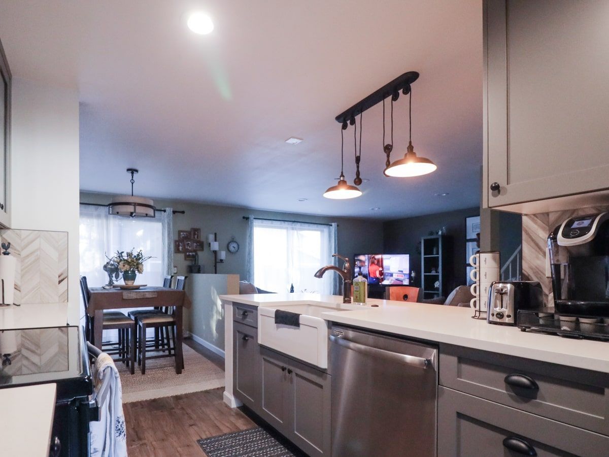 A kitchen with gray cabinets and stainless steel appliances