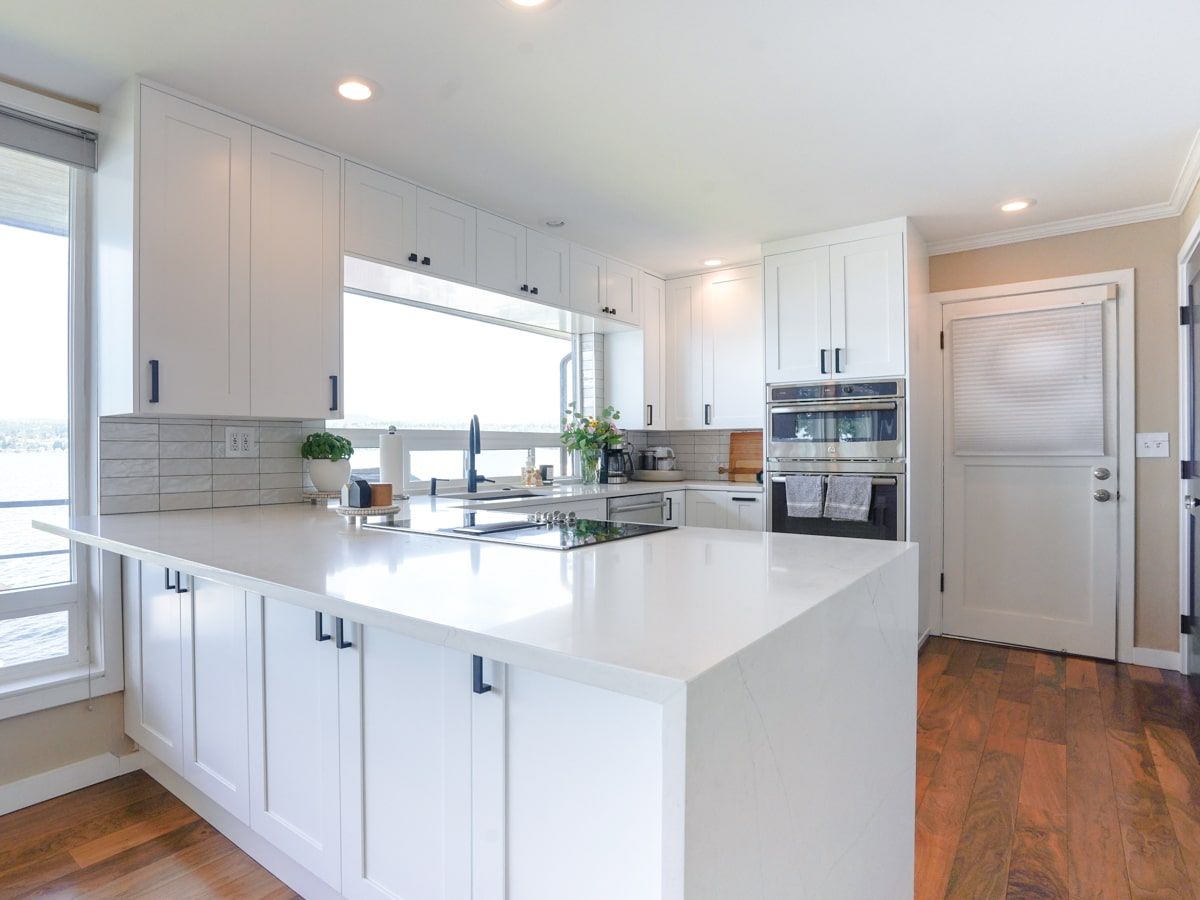 A kitchen with white cabinets and a large island in the middle.