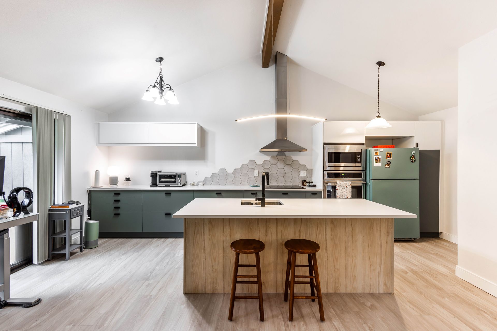 A kitchen with a large island and two stools.