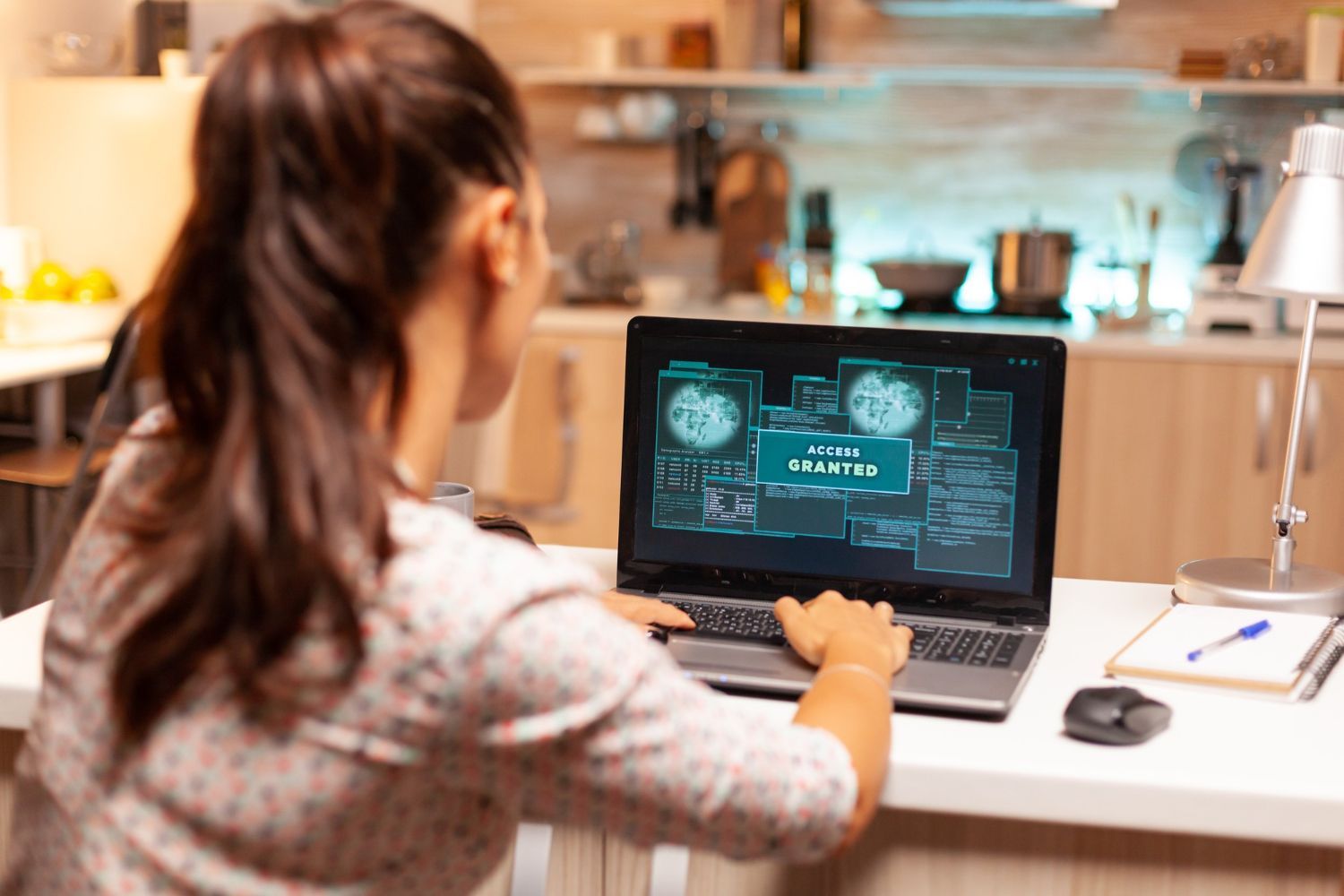 A woman is sitting at a table using a laptop computer.