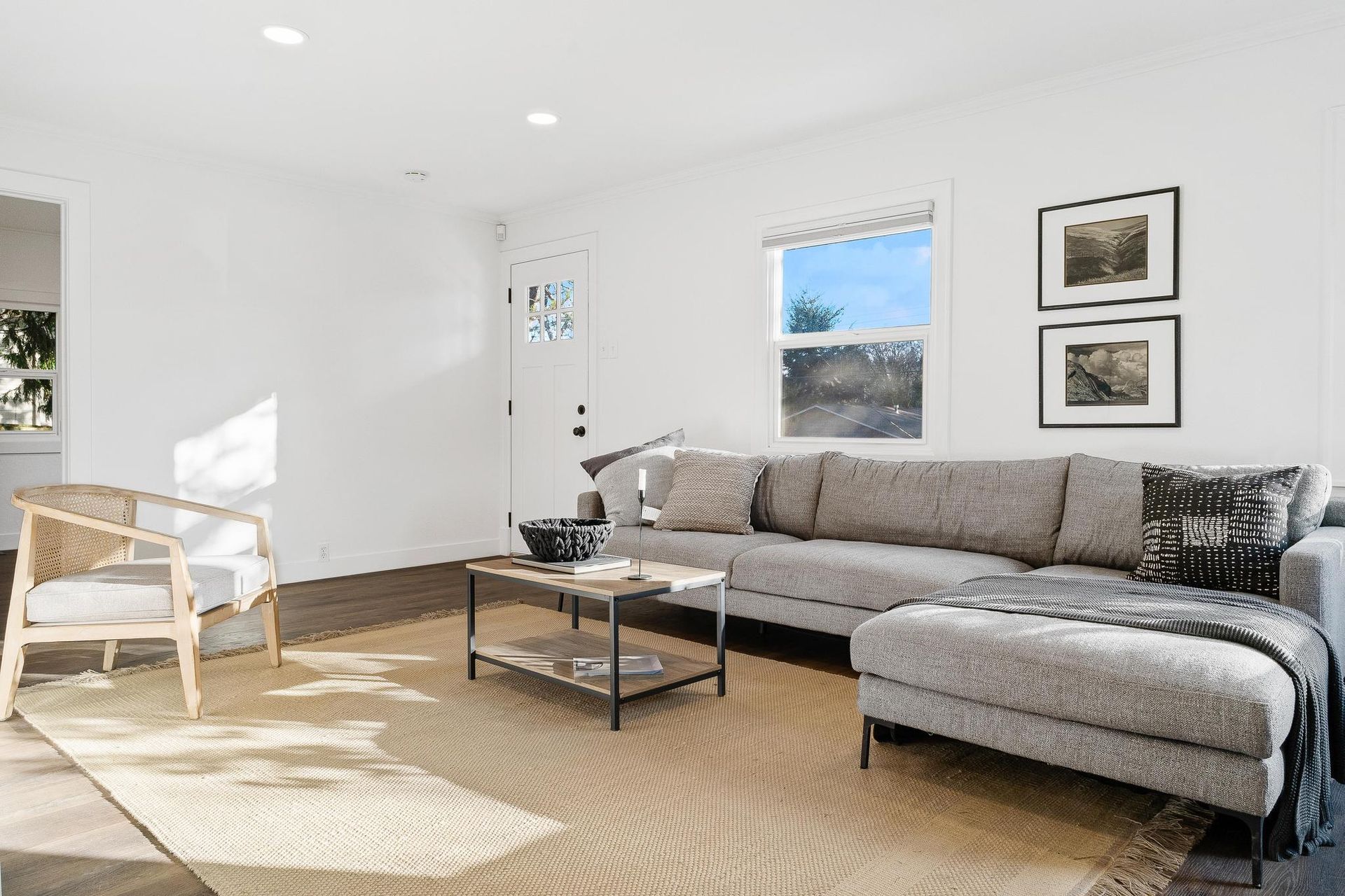 A living room with a couch , chair , coffee table and rug.