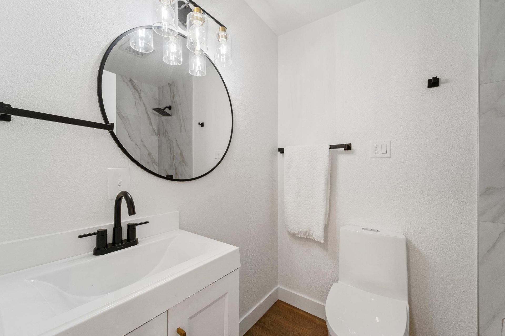A bathroom with a sink , toilet and mirror.