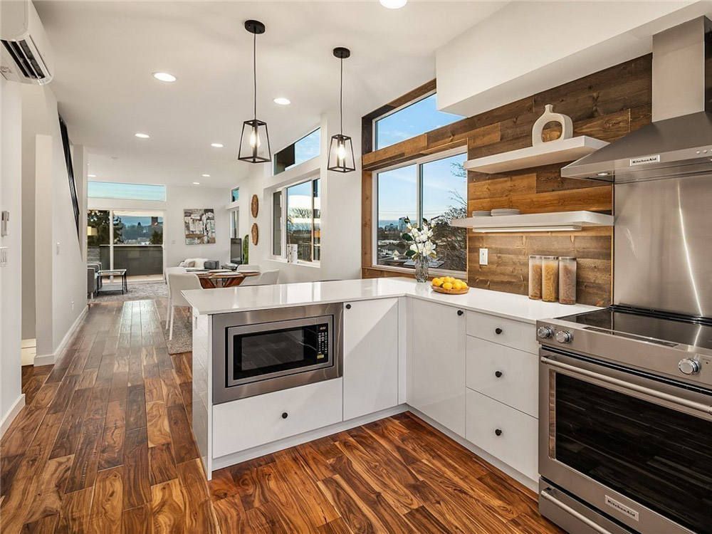 A kitchen with stainless steel appliances and wooden floors