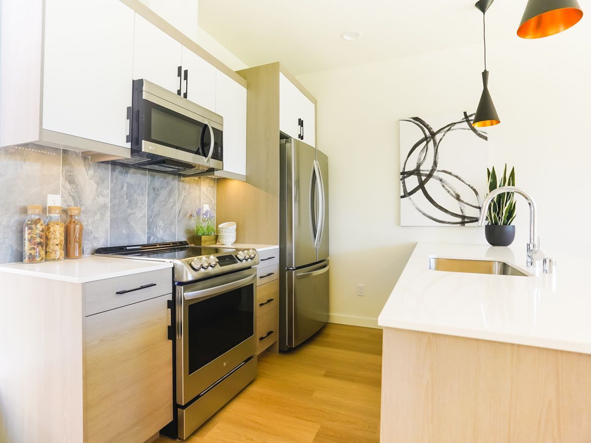 A kitchen with stainless steel appliances and white cabinets.