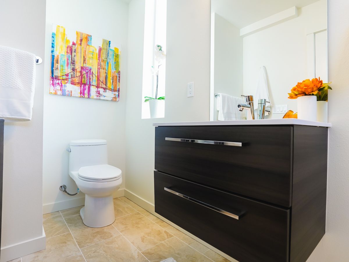 A bathroom with a toilet a sink and a mirror