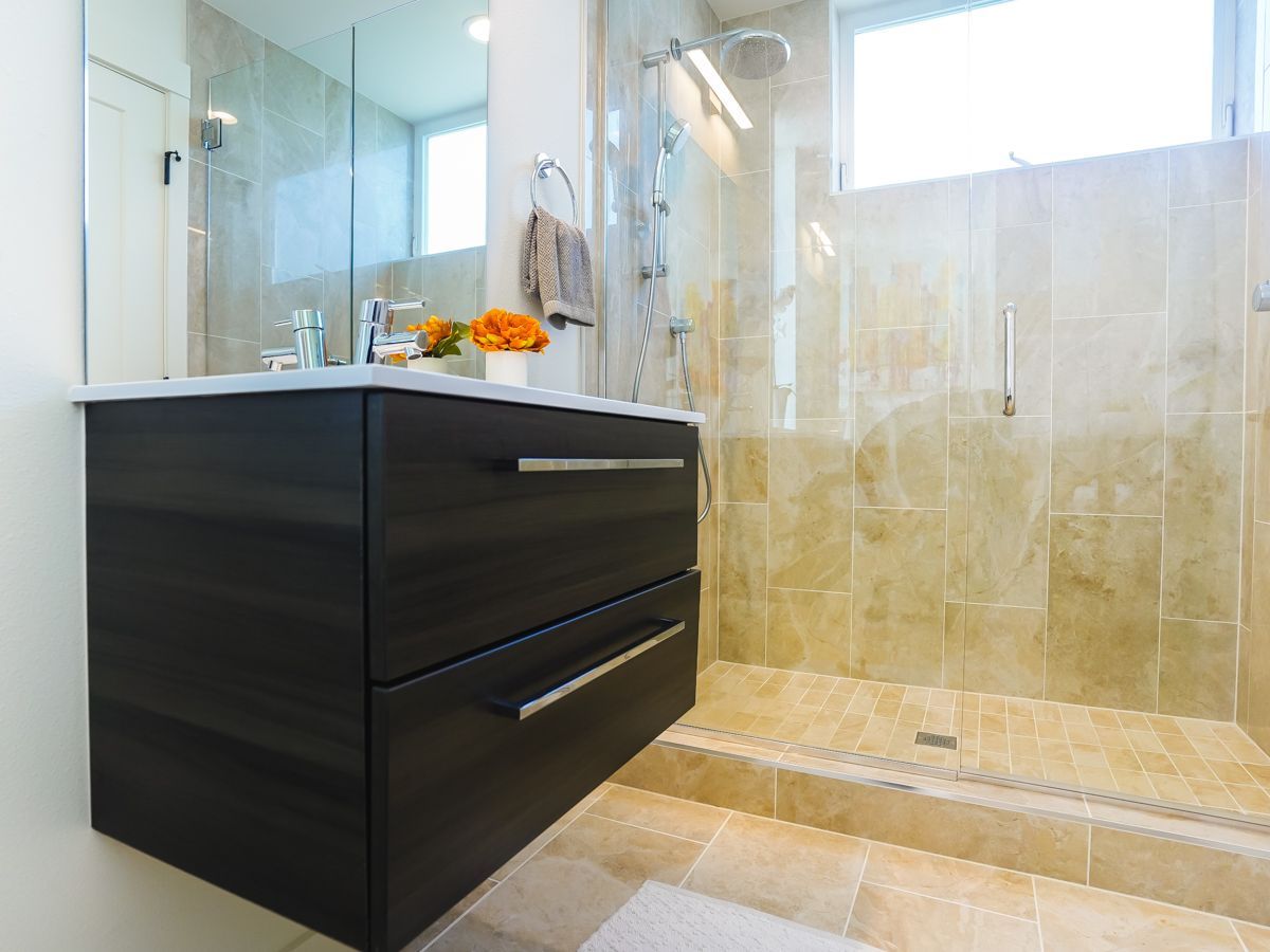 A bathroom with a sink and a walk in shower.
