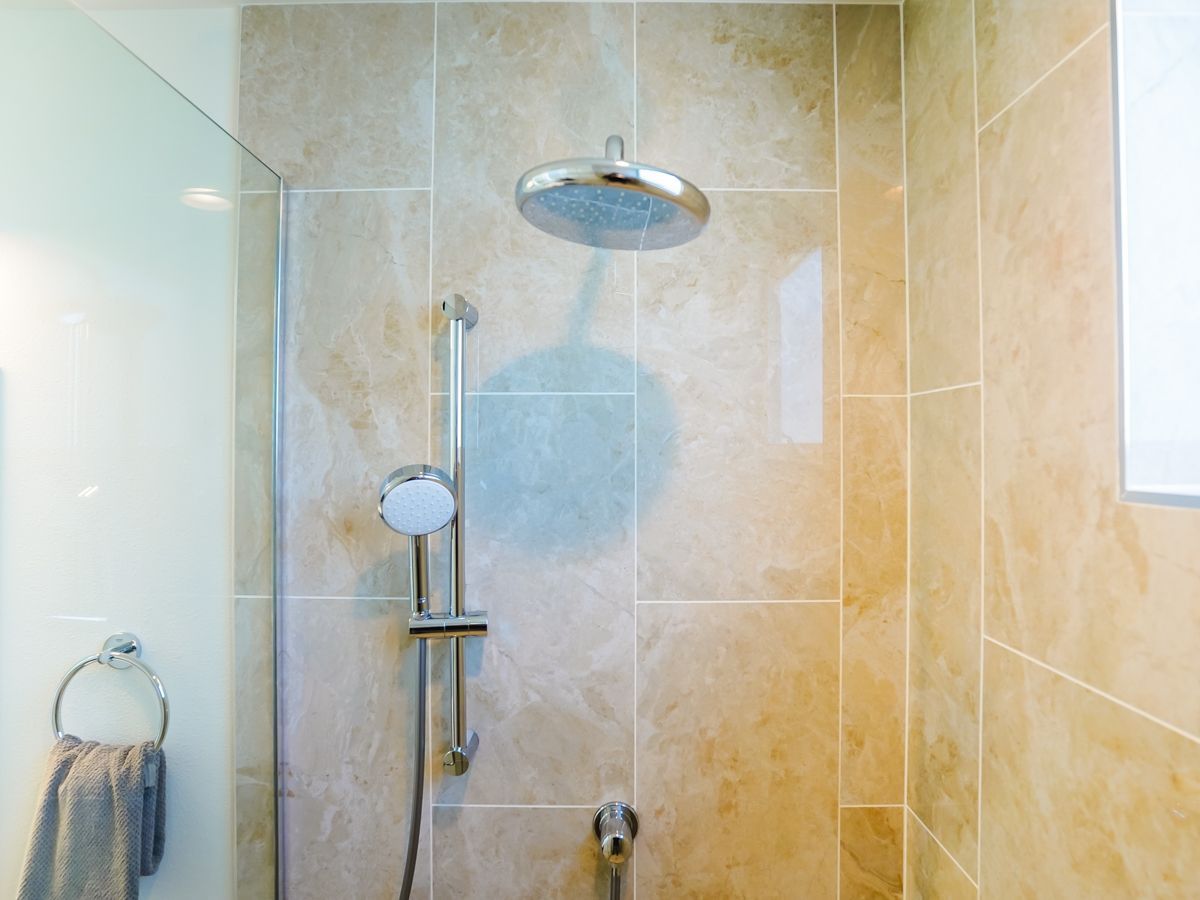 A shower with a glass door and a shower head