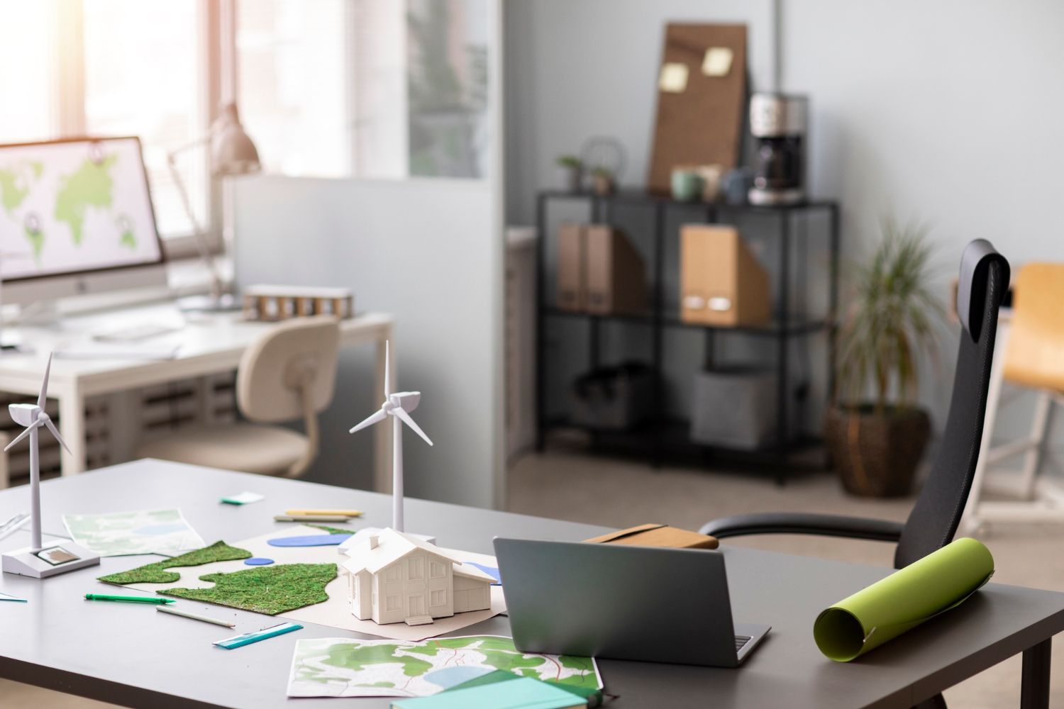 A desk with a laptop and a model of a windmill on it.