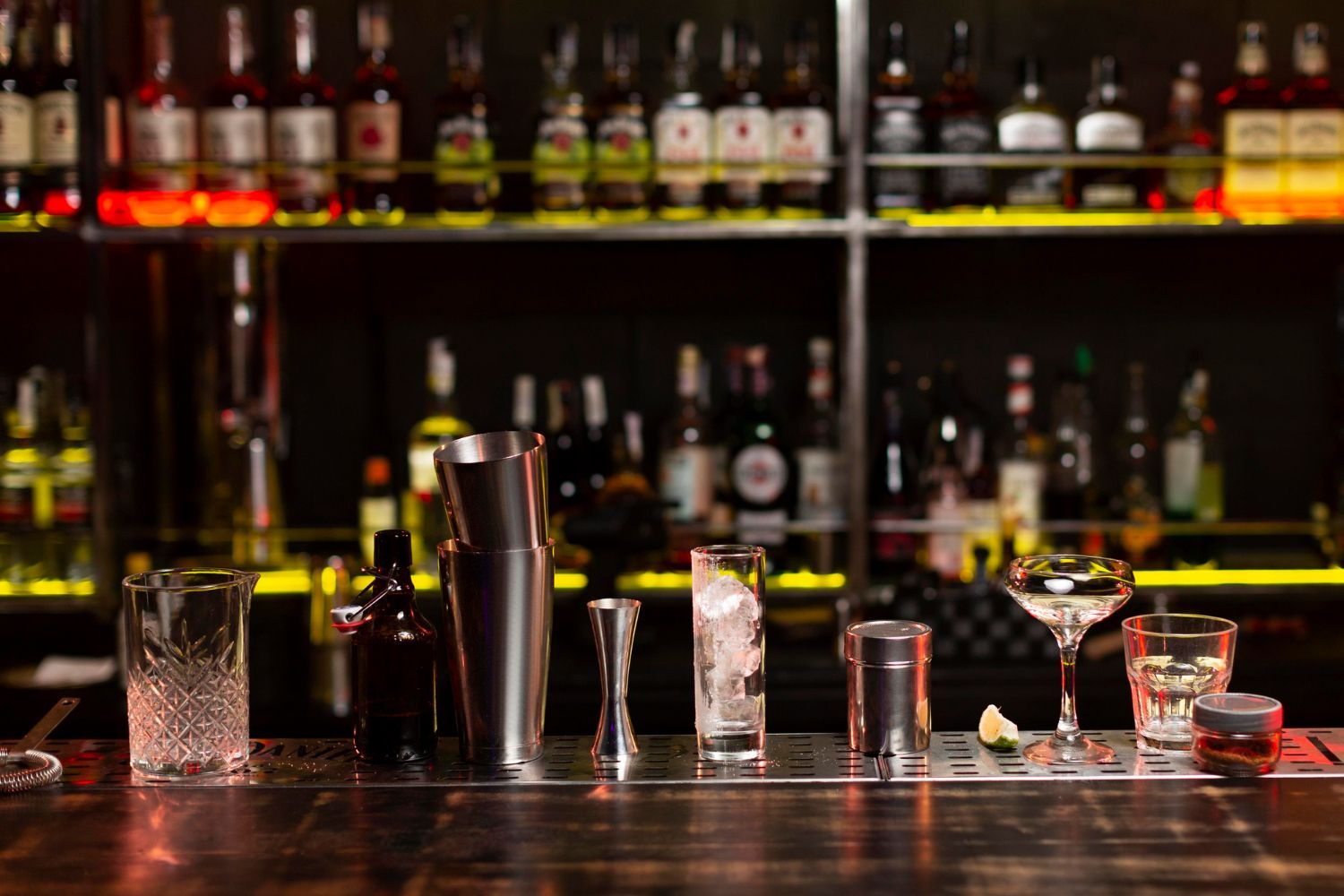 A bar with a lot of bottles and glasses on it.