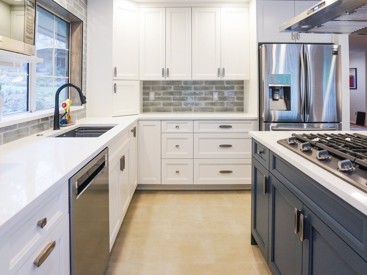 A kitchen with white cabinets and stainless steel appliances
