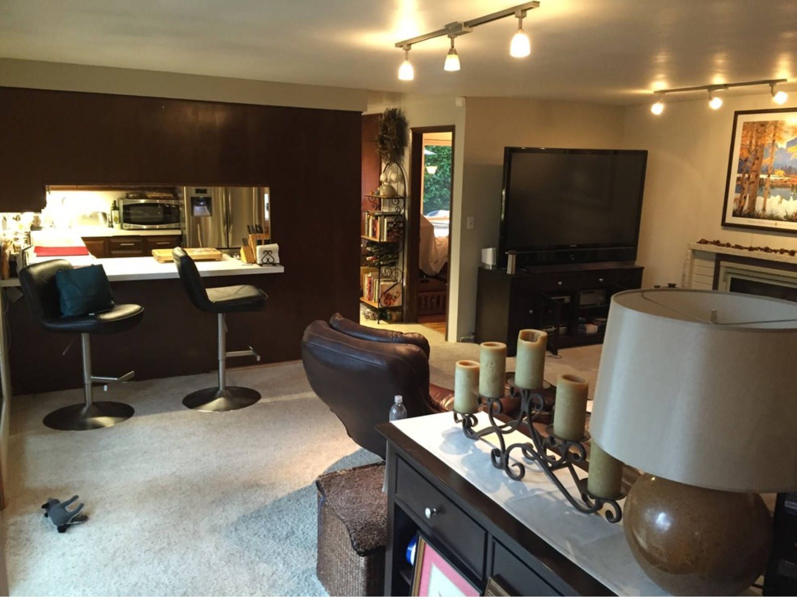 A living room with a large flat screen tv and candles on the table