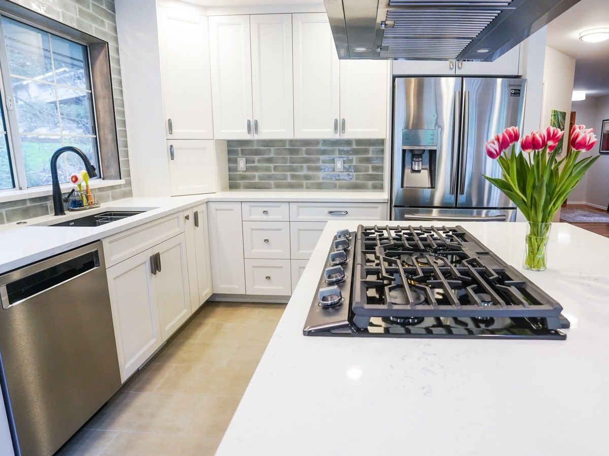 A kitchen with white cabinets and a stove top oven