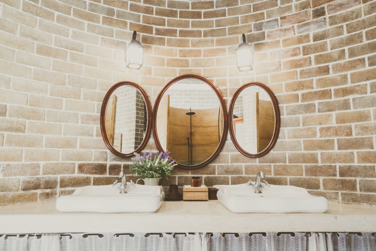 A bathroom with two sinks and three mirrors on the wall.
