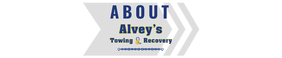 About Alvey’s Towing & Recovery logo in blue and gray on a white background