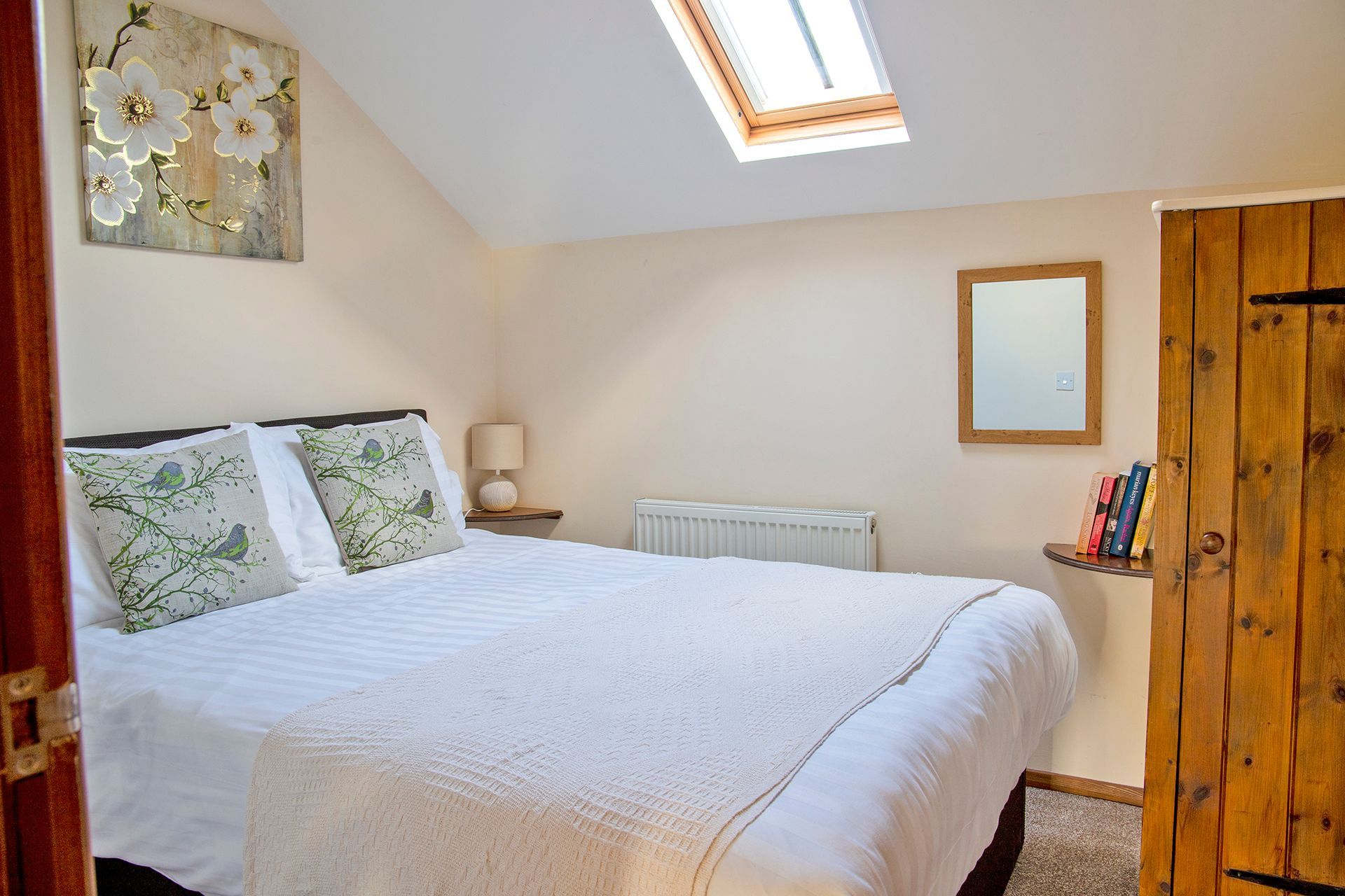 Double bedroom with white linen and green cushions