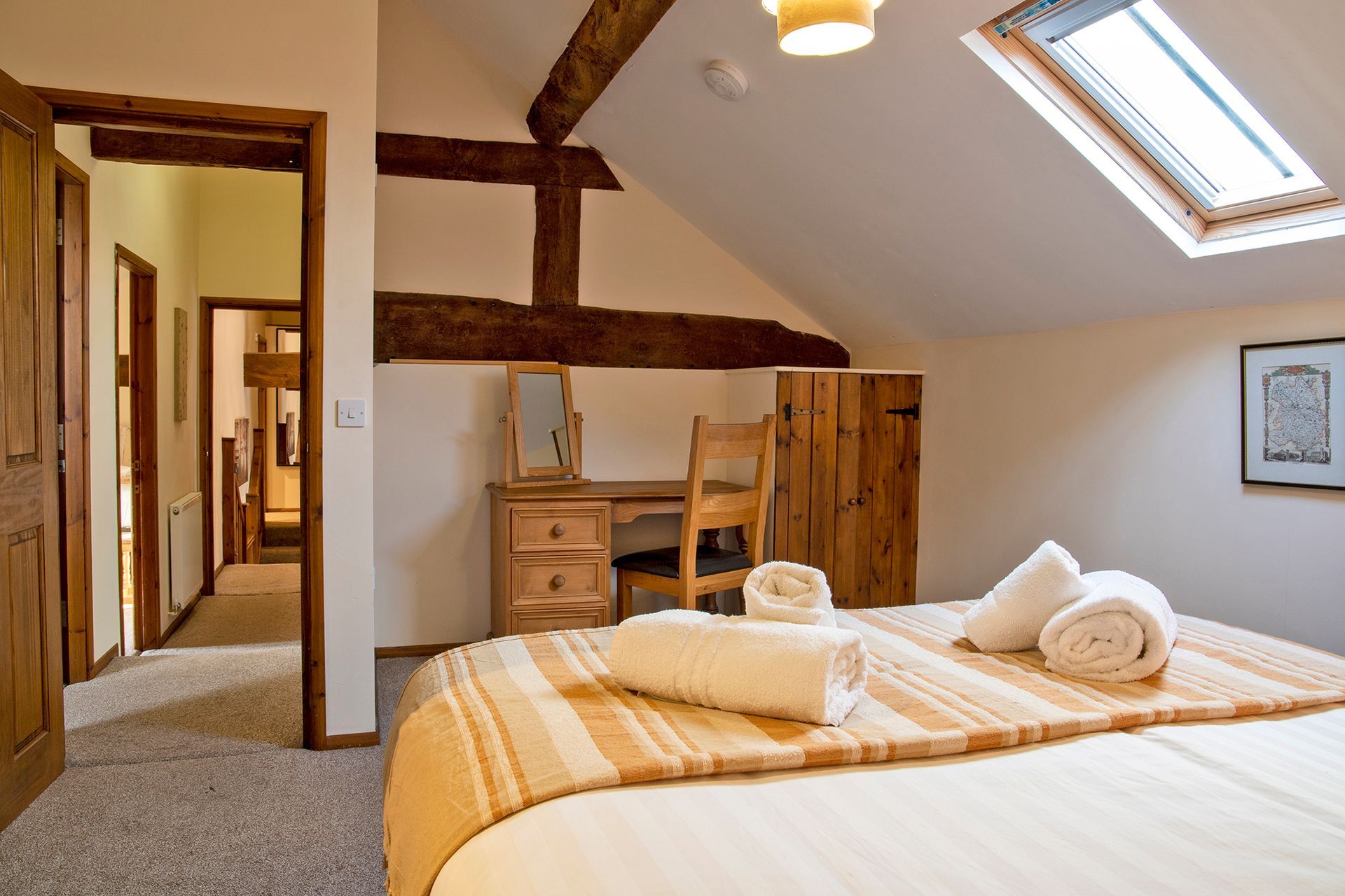 Bedroom with beams looking down the corridor