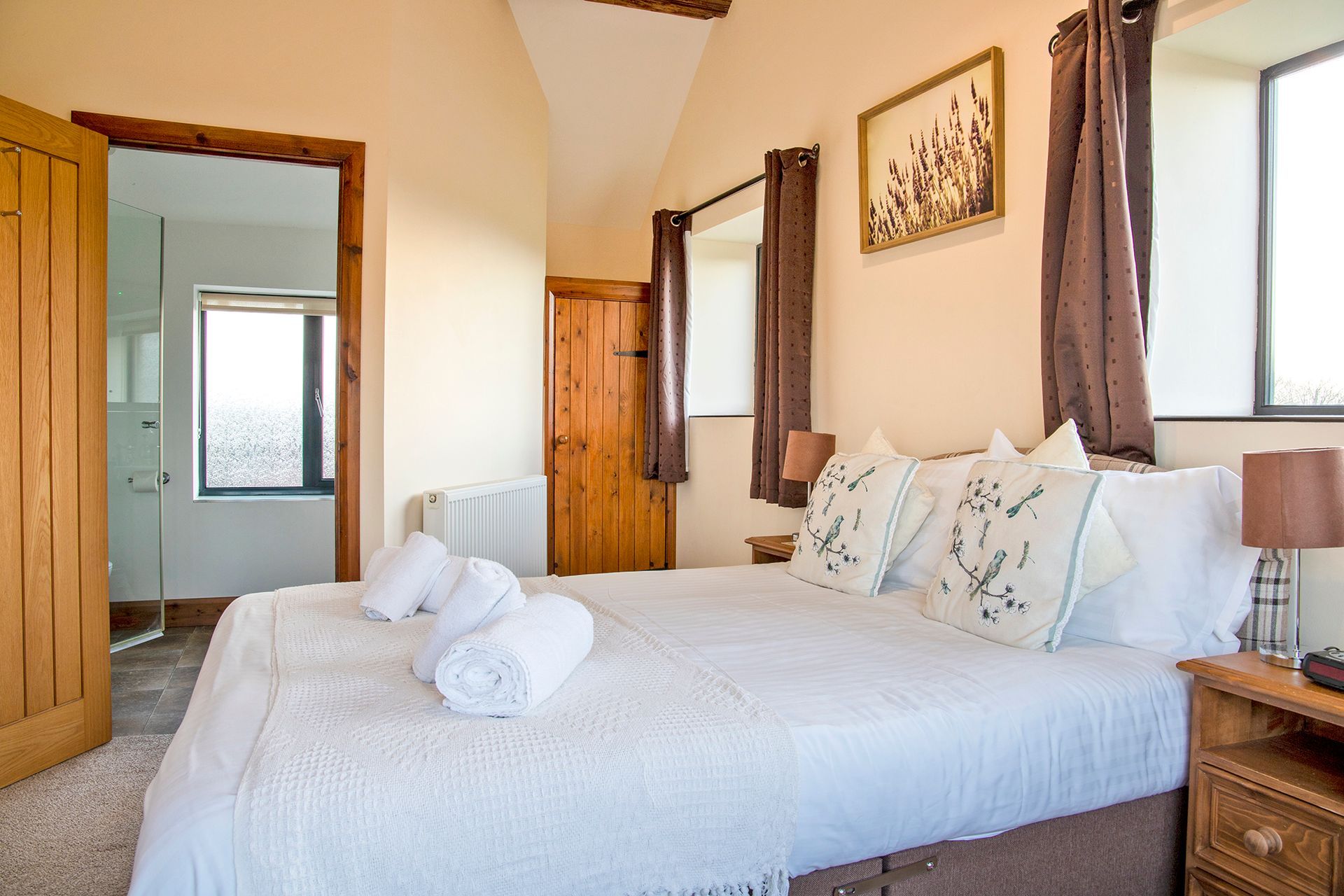 Double bedroom with white linen and en-suite shower room