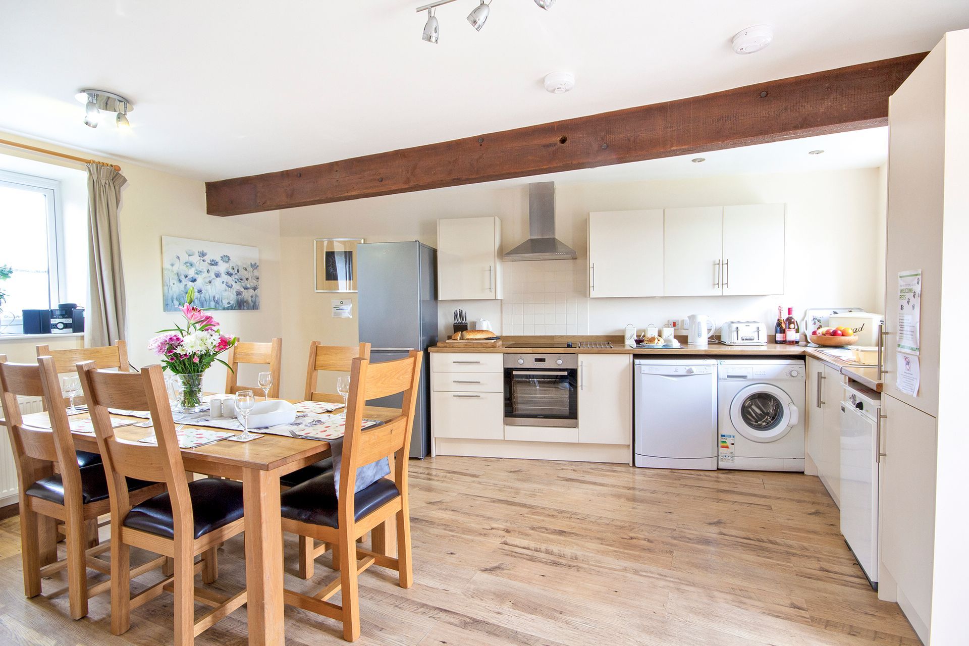 Modern kitchen with washing machine, oven and fridge and dining table