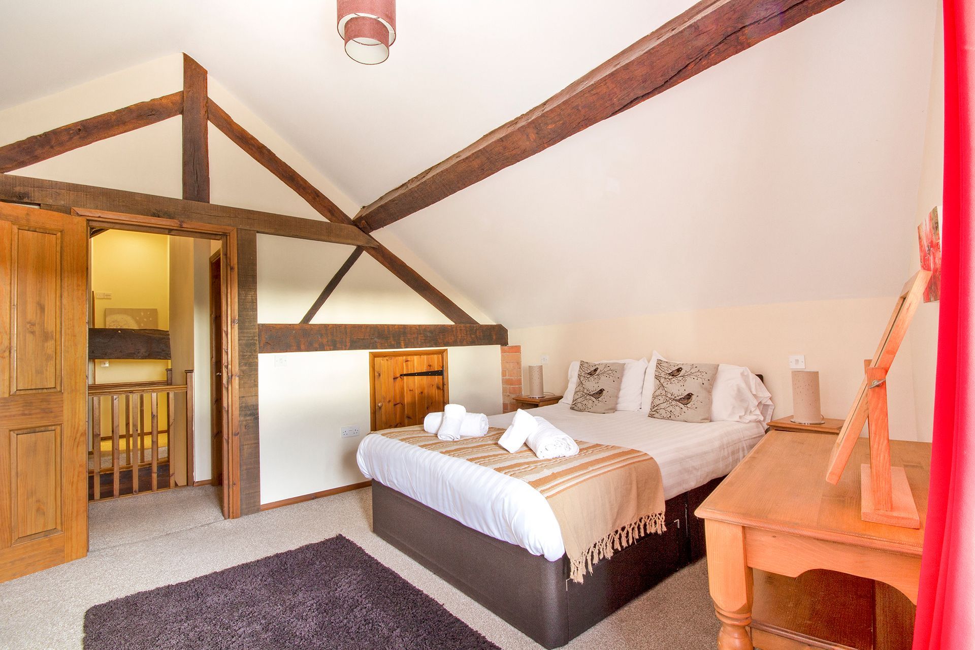 King size bedroom with rolled towels, oak beams, oak door