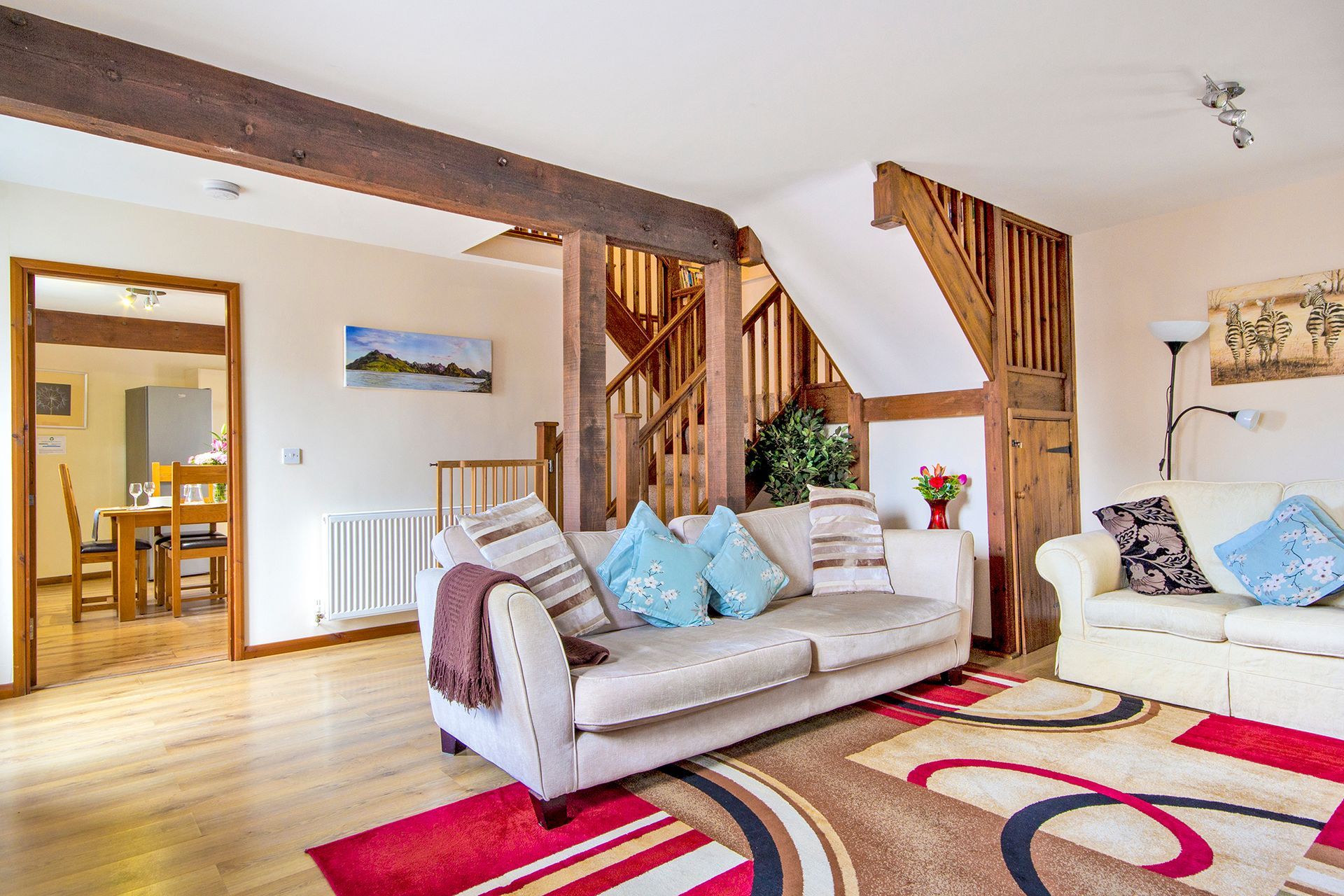 Sitting room with cream sofa's and wooden staircase