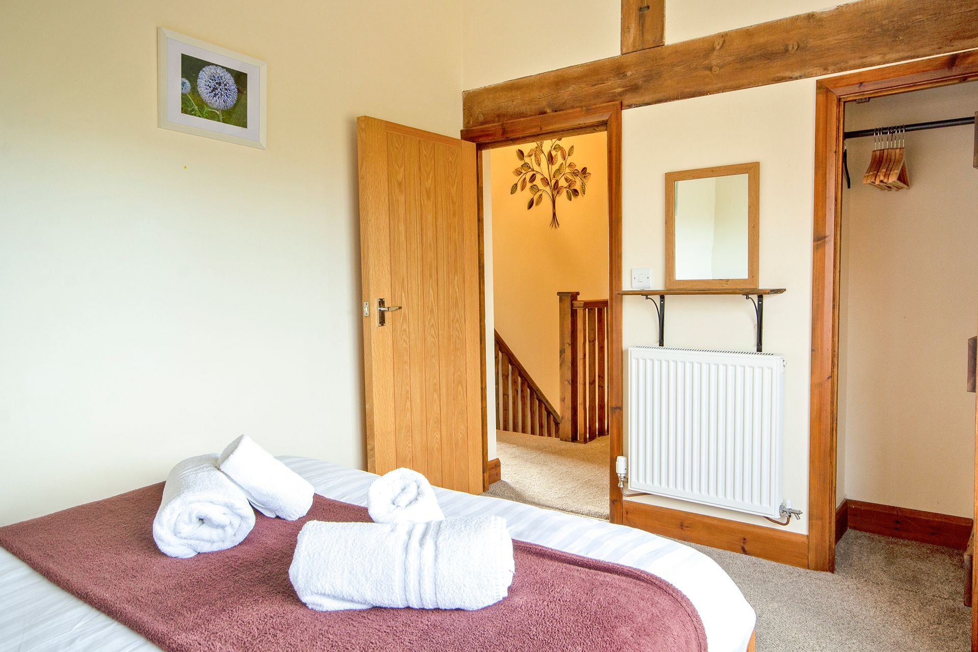 Open door showing staircase and bedroom with beams