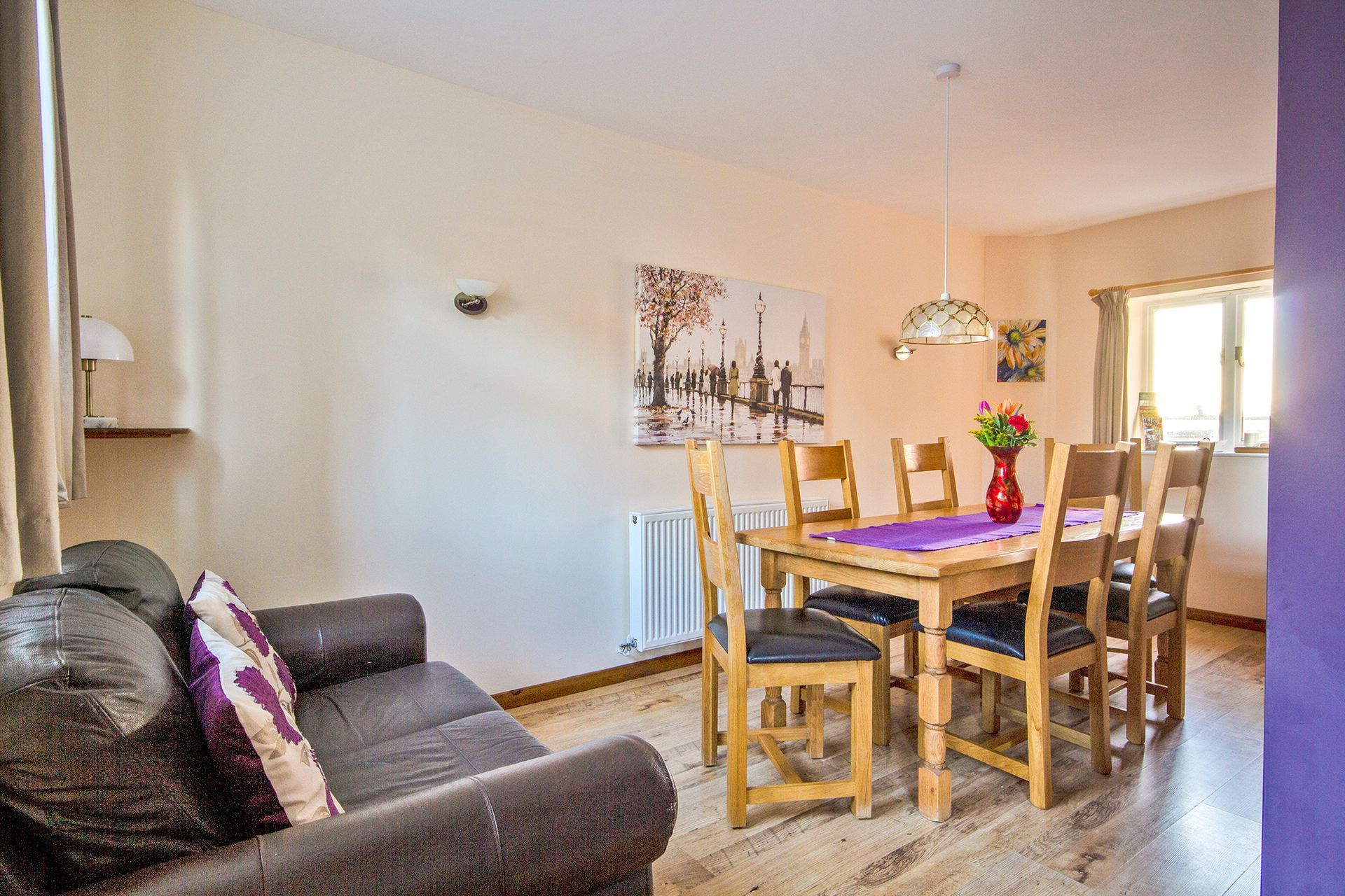 Dining table with a vase of flowers and sofa