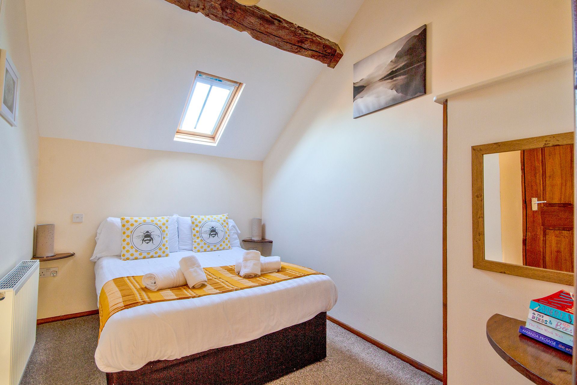 double bedroom with bumble bee cushions