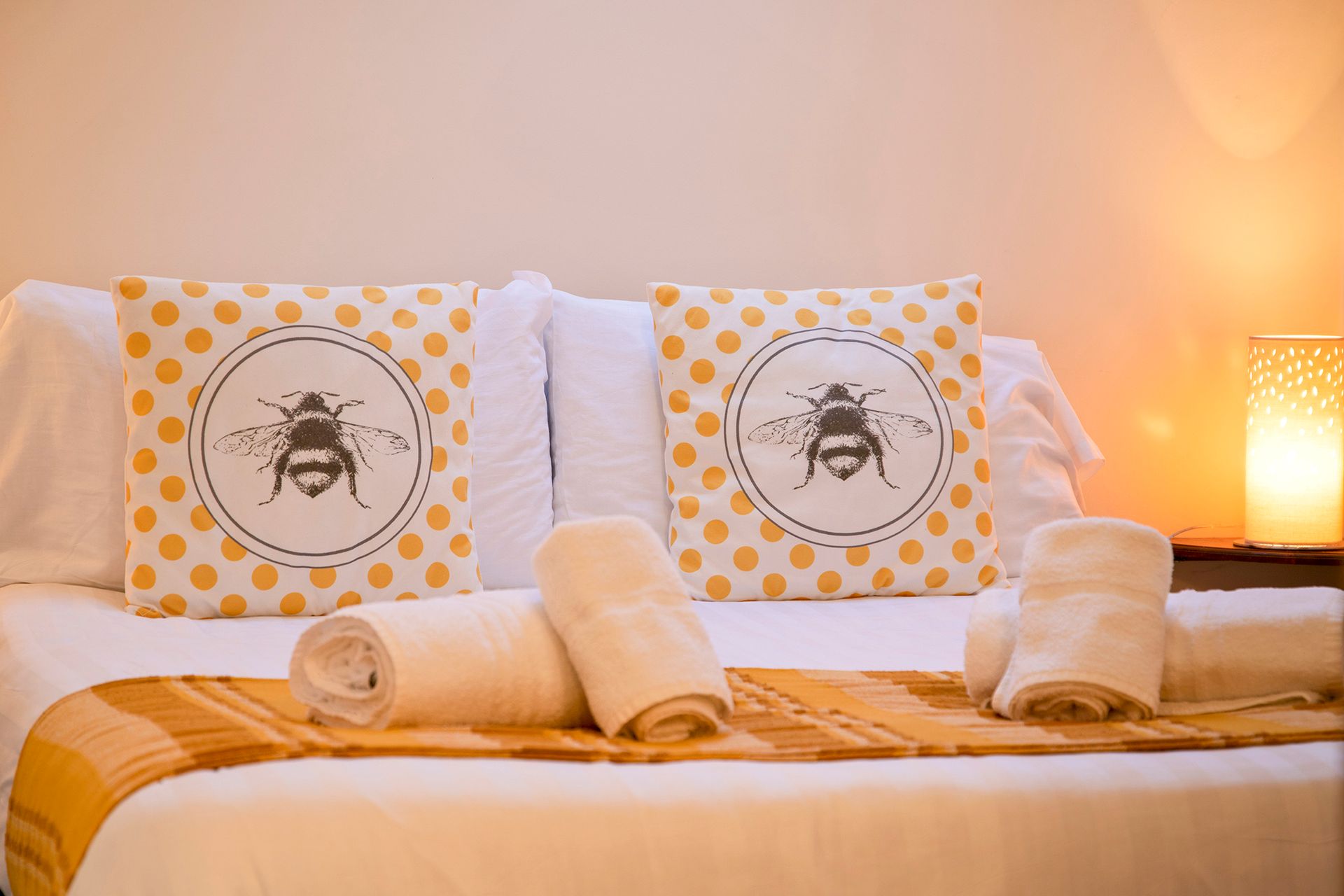 A double bedroom with 2 large yellow bee cushions