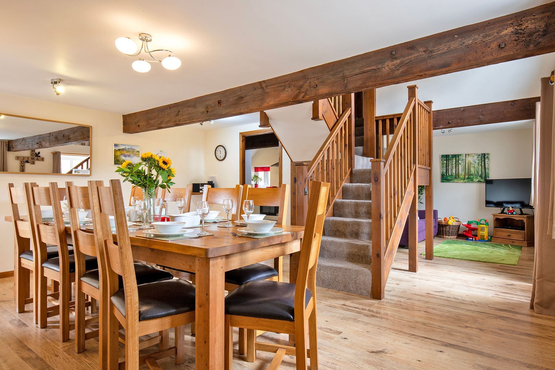 Laid dining table and chairs, open plan with beams