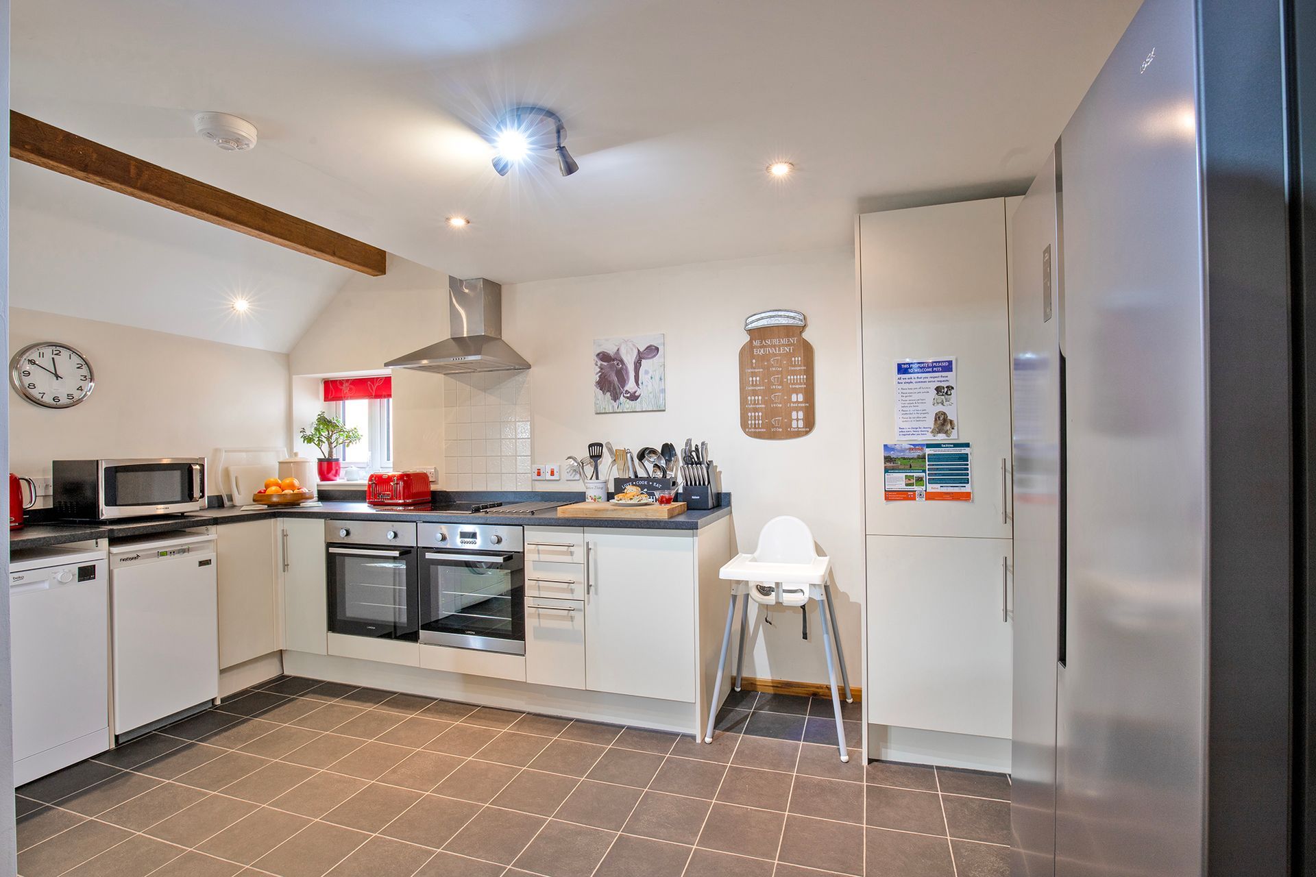 Modern cream kitchen with American fridge freezer, ovens, highchair