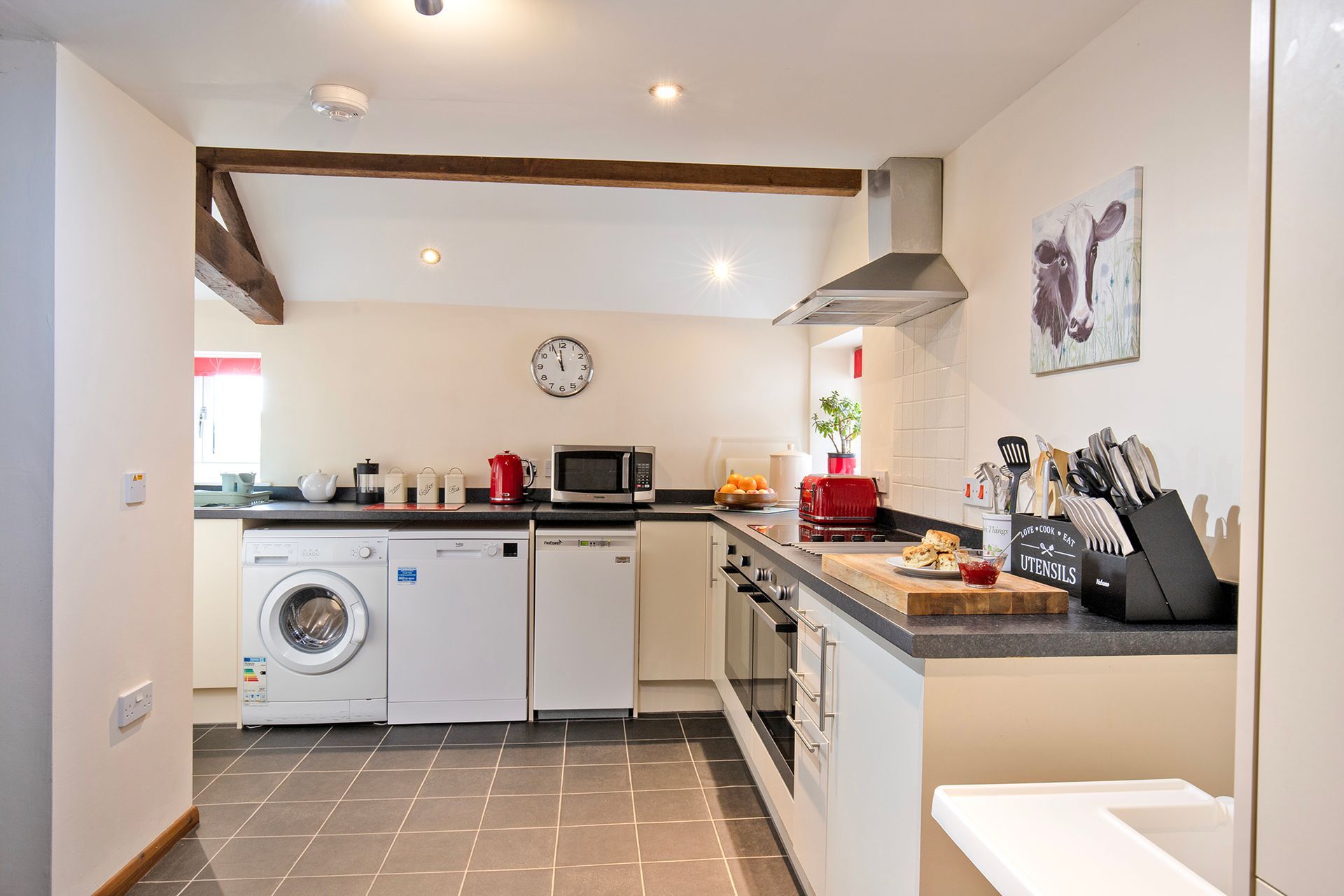 Modern kitchen with washing machine, oven and oak beams