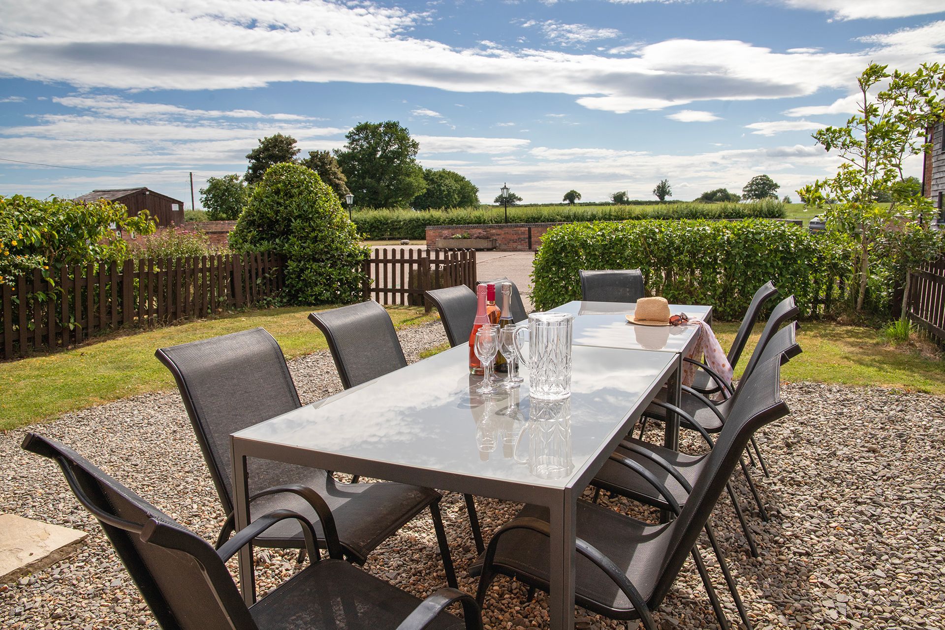 Patio table with wine bottles and glasses with countryside views