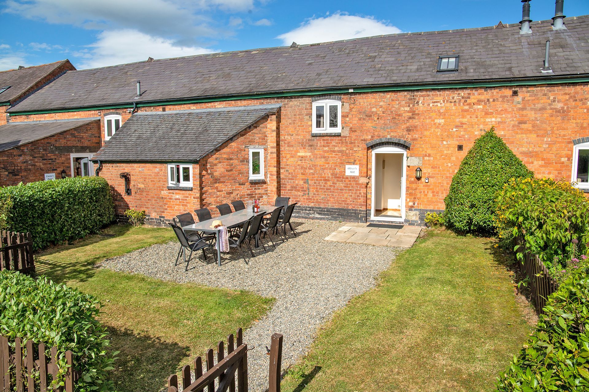 Georgian brick built holiday cottage with enclosed garden and patio table and chairs on a sunny day