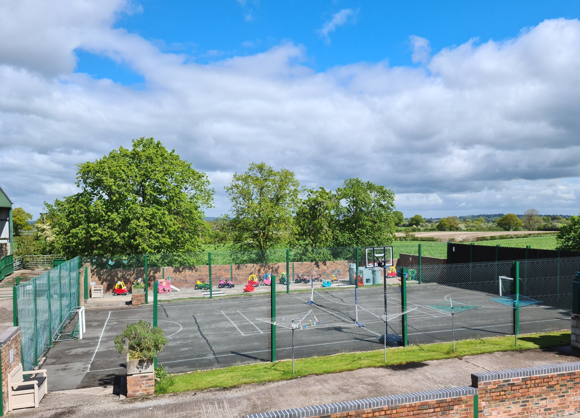 Looking out over a sports court and play area with trees
