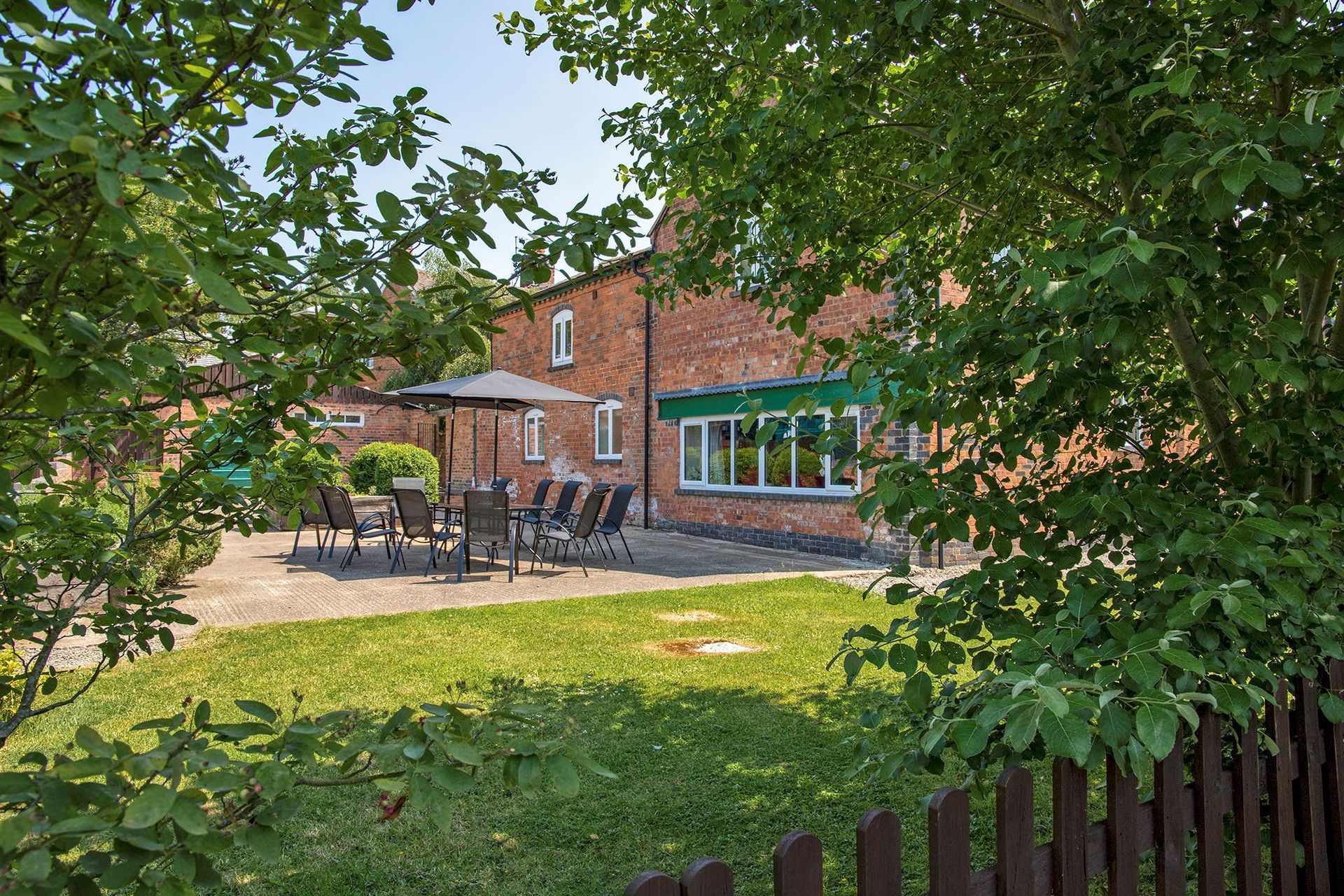 Looking through trees into a patio and garden area
