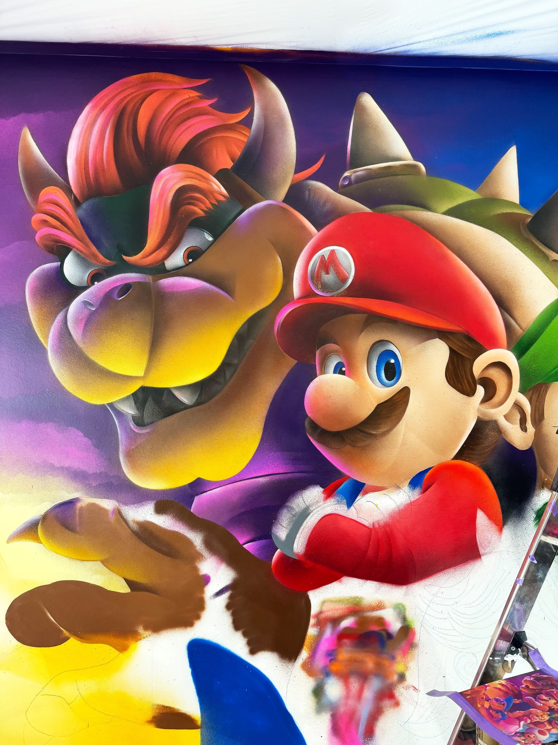 Gedetailleerde weergave van Bowser en Mario met kleurrijke lucht in de Mario Bros muurschildering.