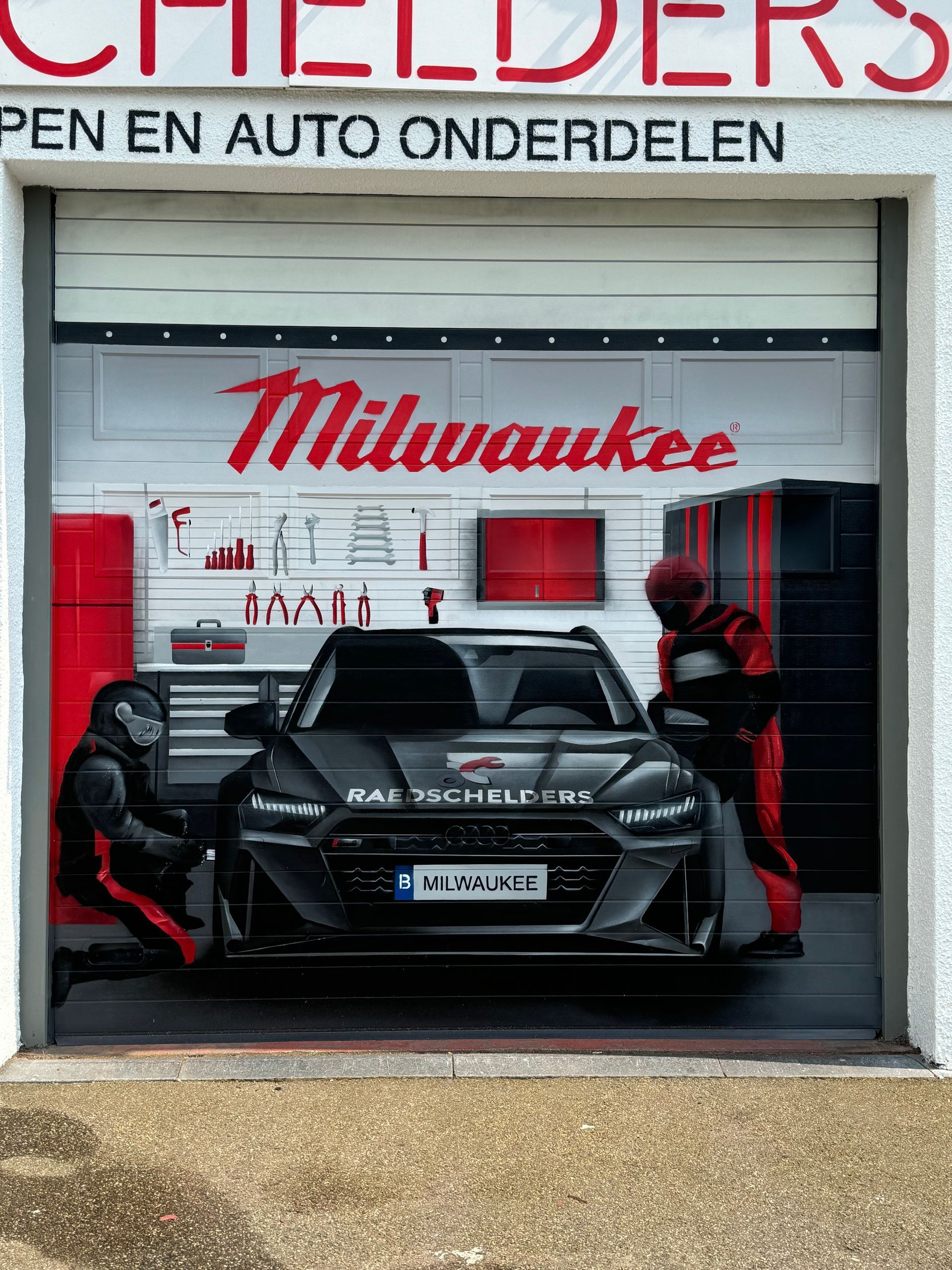 Realistische muurschildering van een geopende garagepoort met een Audi RS6 op Circuit Zolder, gemaakt voor Raedschelders Borgloon