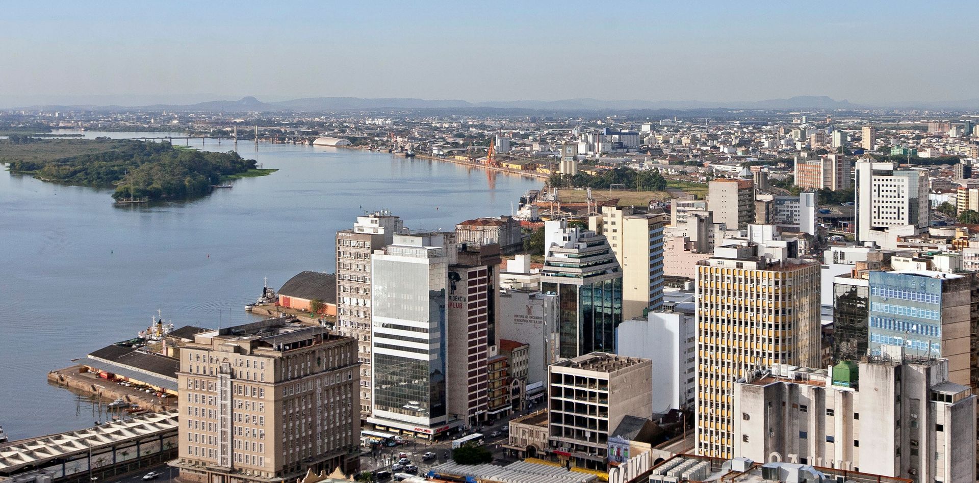 Uma vista aérea de uma cidade com uma grande massa de água ao fundo.