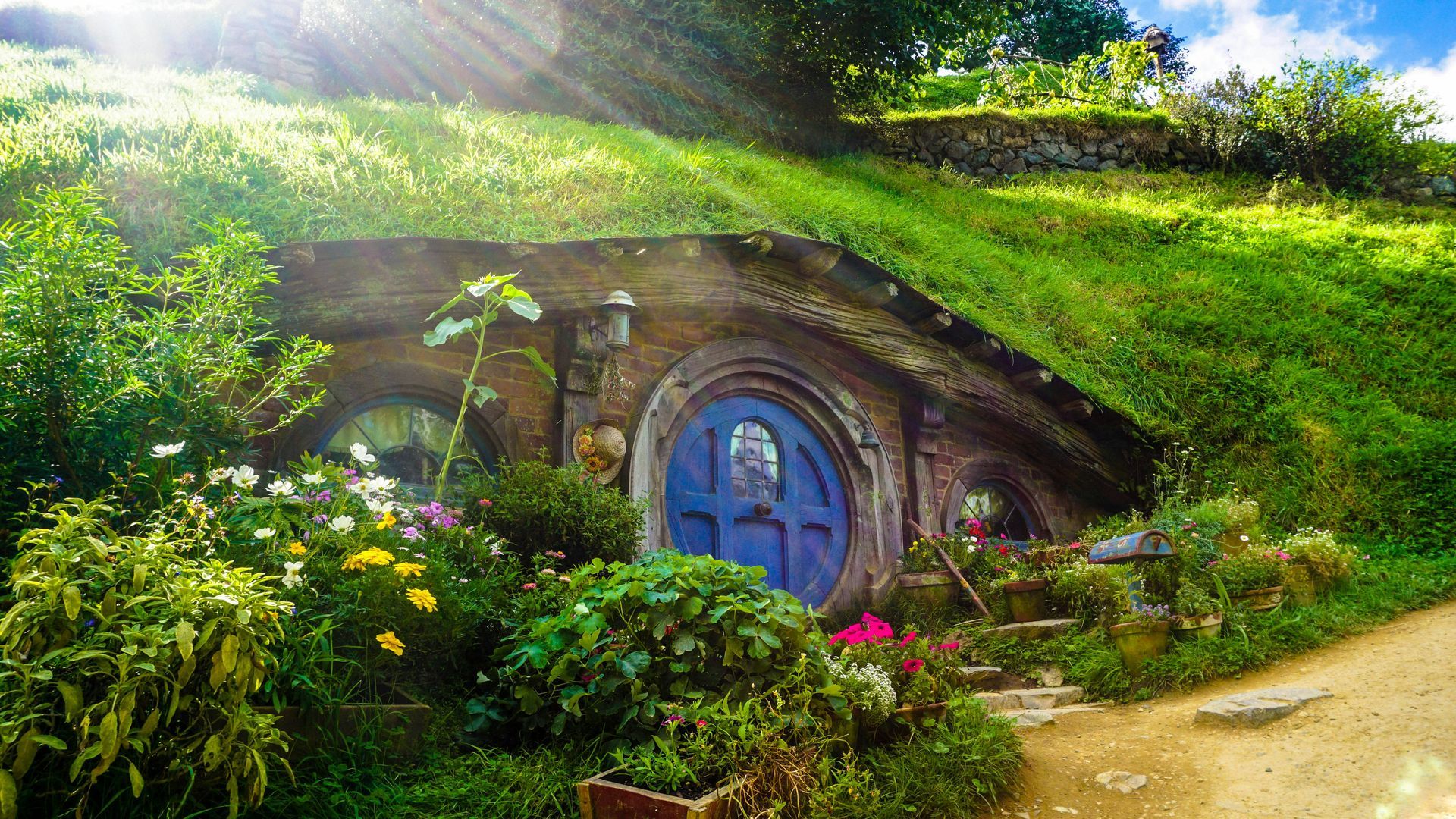 Uma pequena casa com uma porta azul está situada no topo de uma colina.