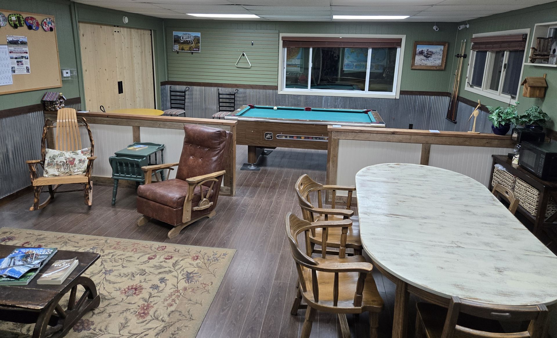 Recreation room with pool table, seating area, wooden accents, and a large oval table.