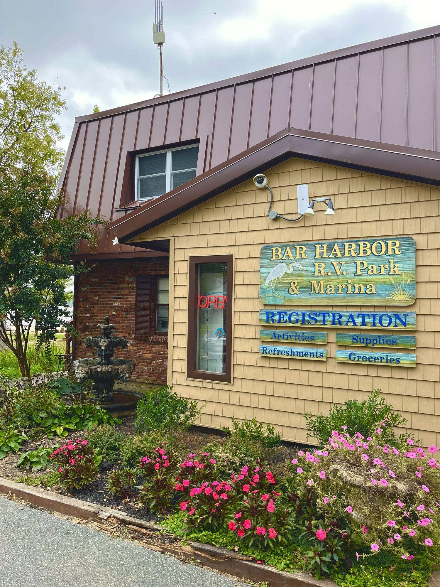 Park entrance sign for Eagle Harbor Recreation Center beside a flower bed and tan building