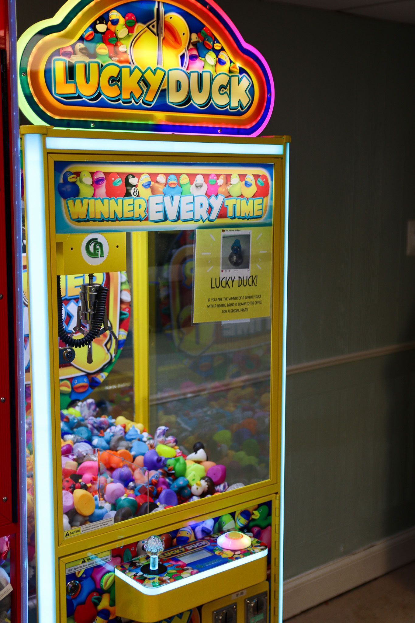 Colorful Lucky Duck arcade claw machine filled with small prizes and bright lights