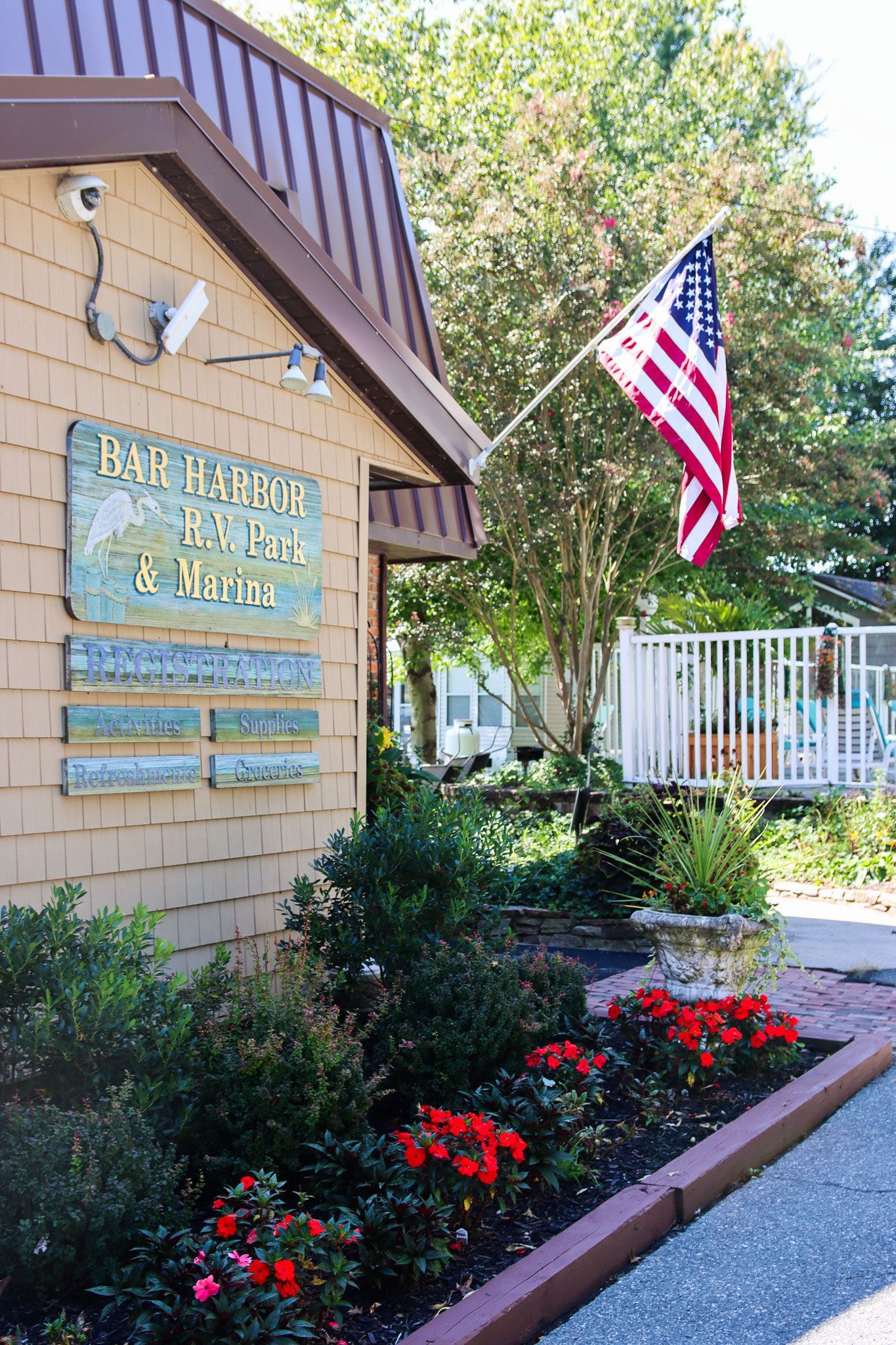 Exterior of a building with an American flag, garden flowers, and a sign reading “Day Program for Adults”