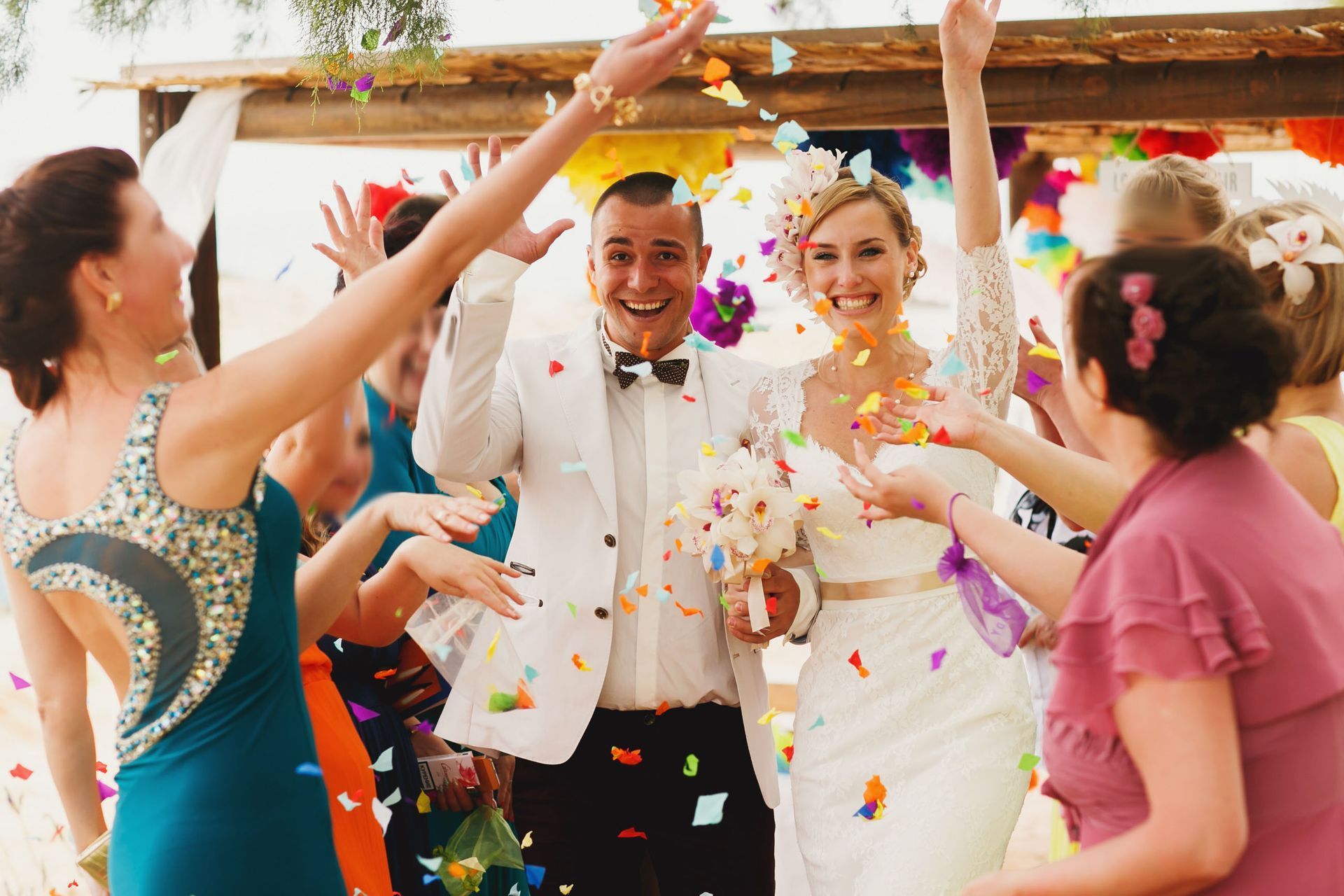Wedding couple celebrating with guests as confetti falls at an indoor party