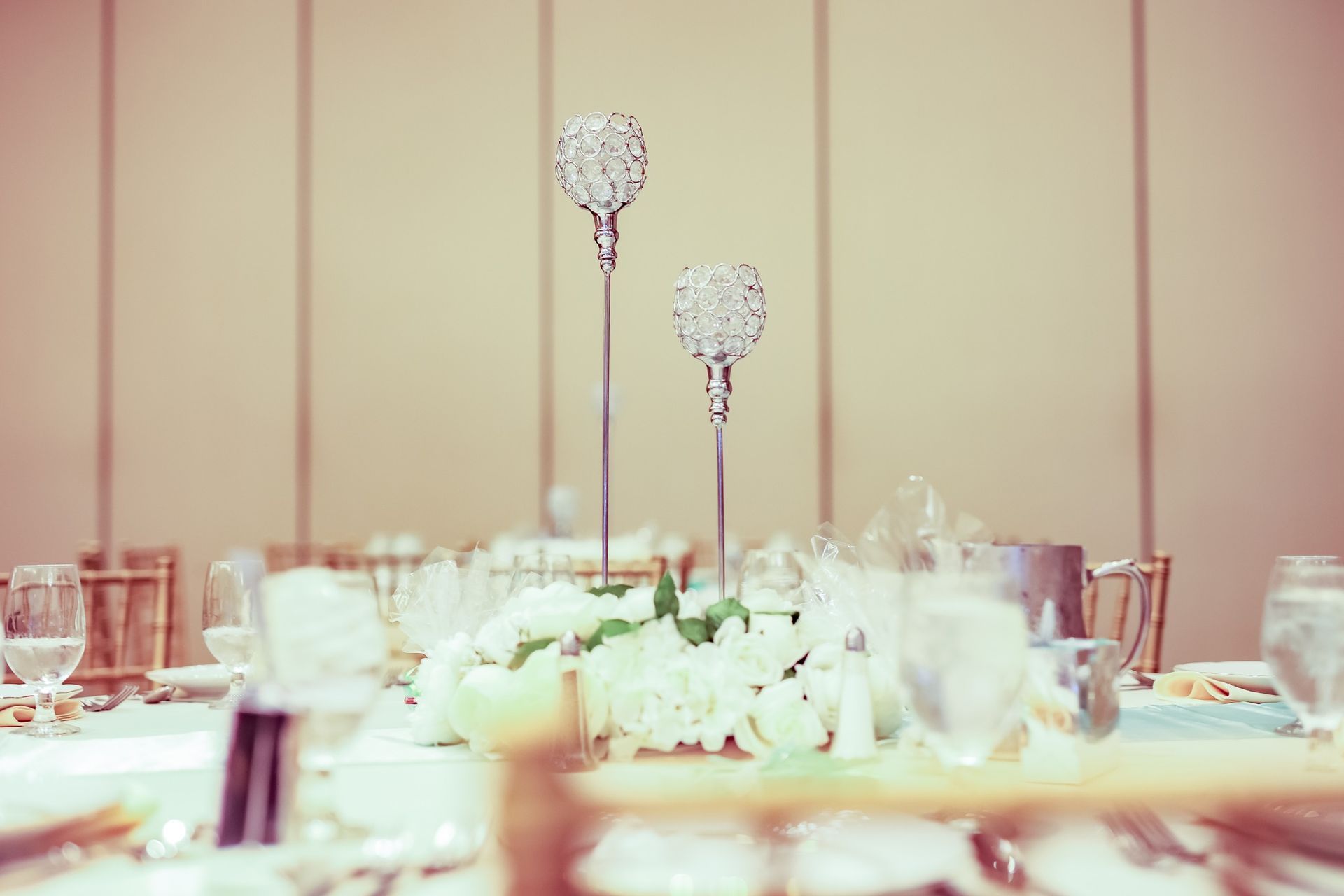 Elegant banquet table with white floral centerpieces and tall crystal candle holders