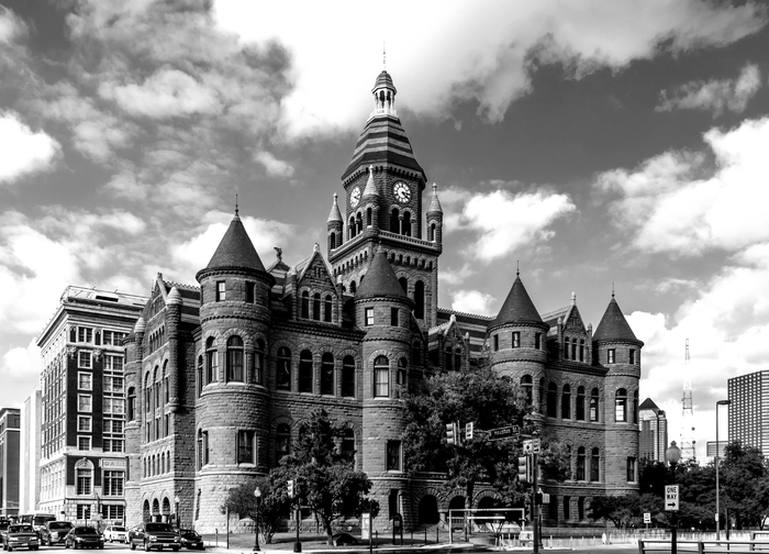 A black and white photo of a large building with a clock tower.